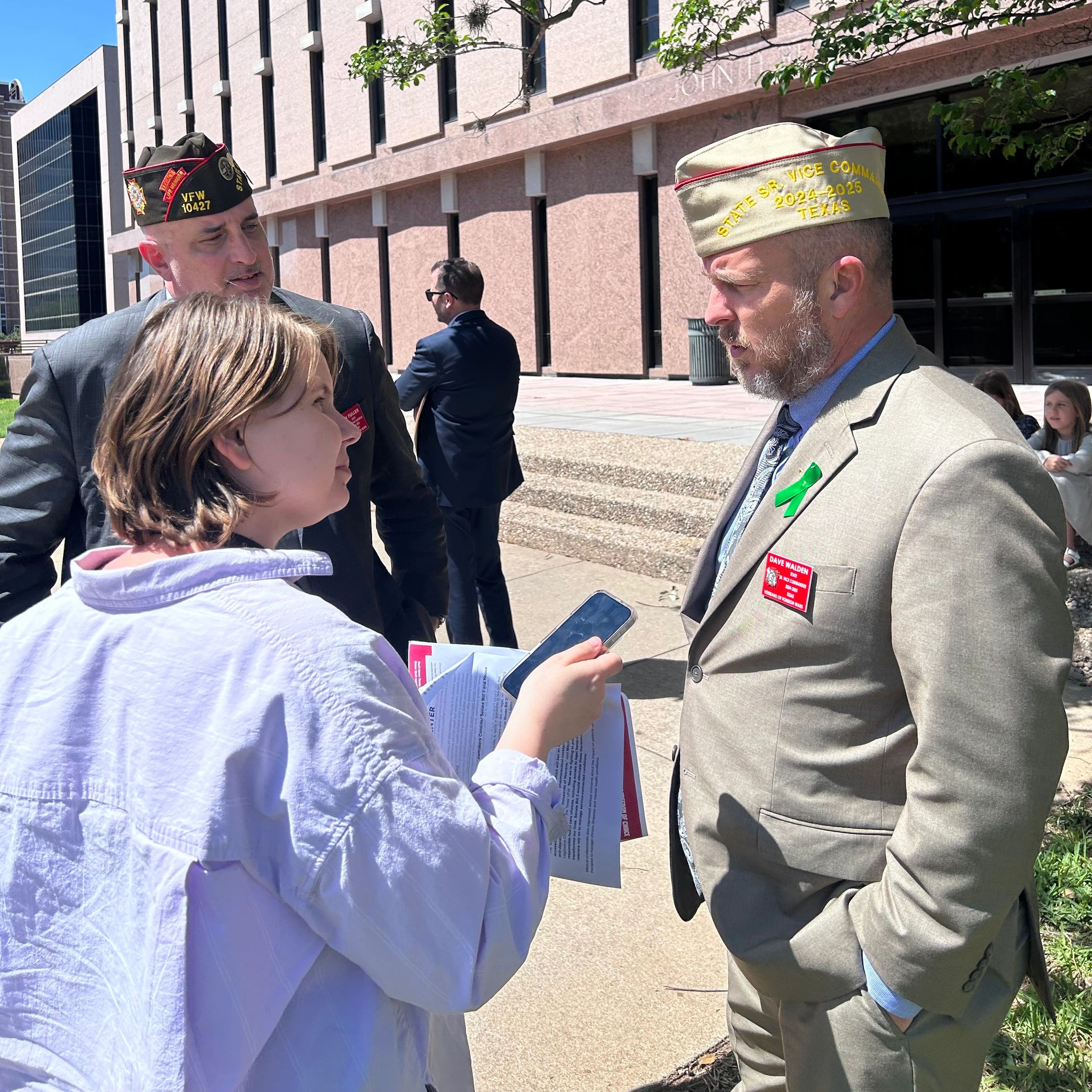 Dave Walden of the Texas VFW talking with people outside a Capitol complex building