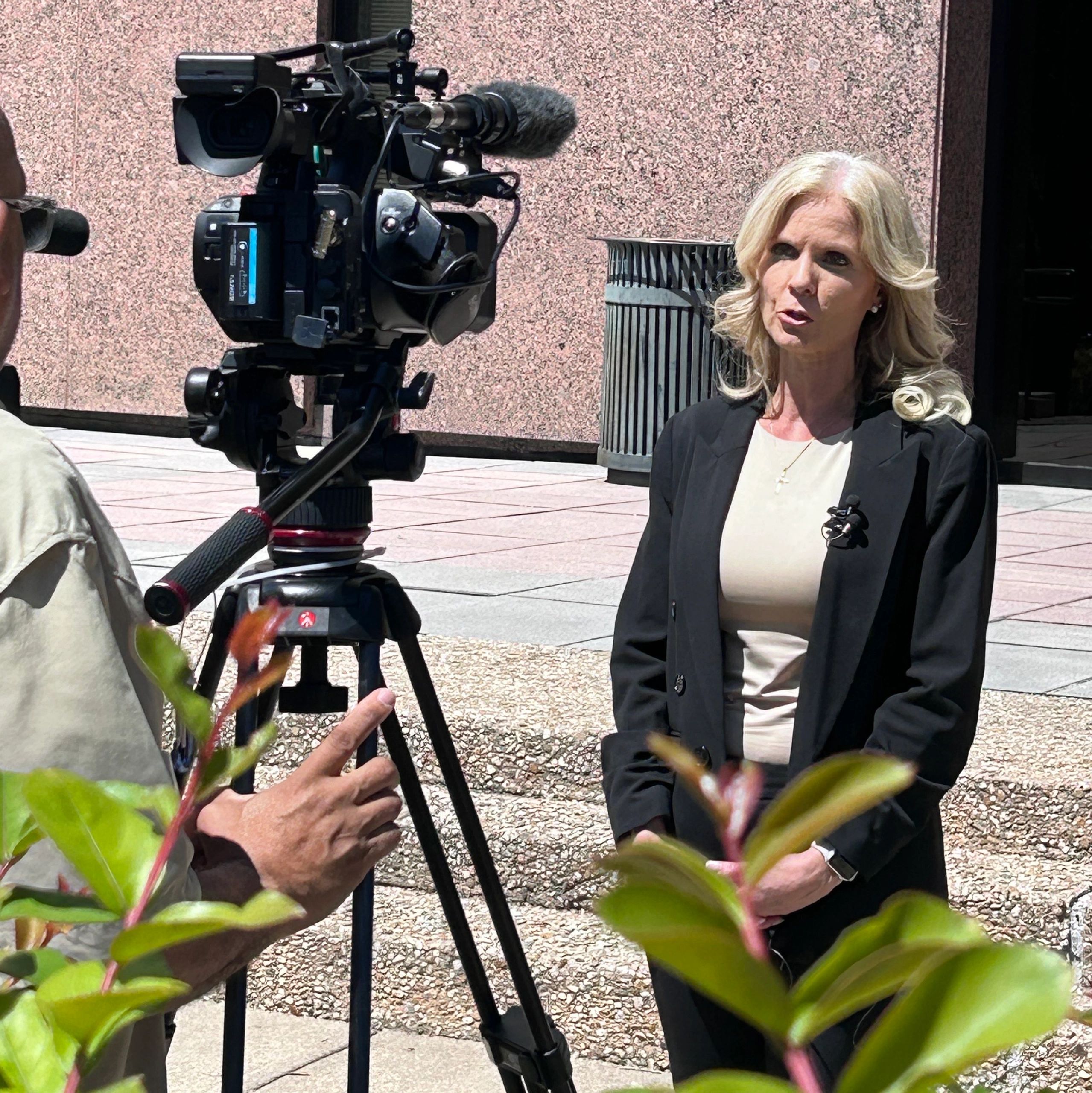 A woman being interviewed by a television camera crew outside the Capitol