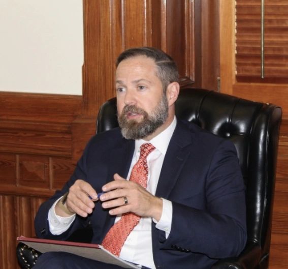 Speaker Dustin Burrows seated in an office during an interview