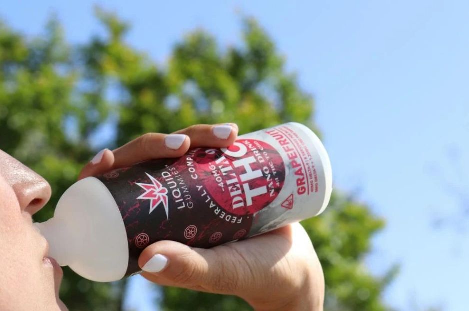 A person drinking from a can of a hemp-derived THC beverage
